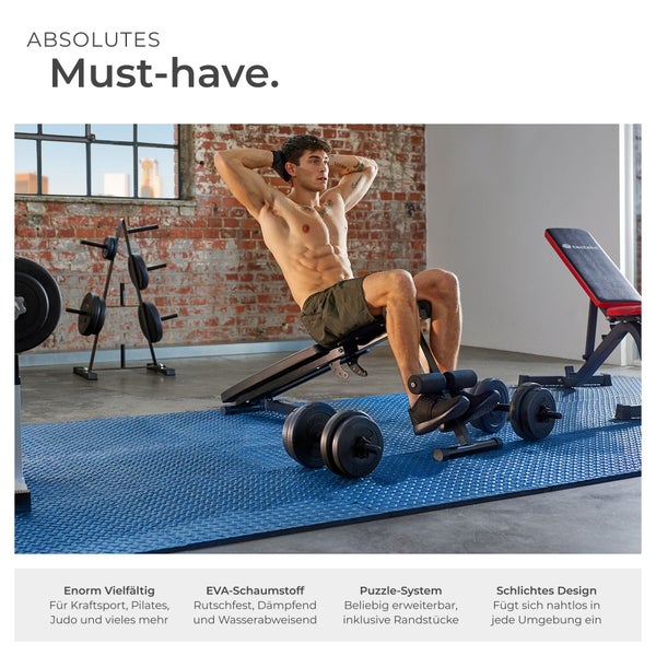 Mann trainiert Bauchmuskeln auf einer Hantelbank in einem Fitnessstudio mit Gewichten und blauen Trainingsmatten