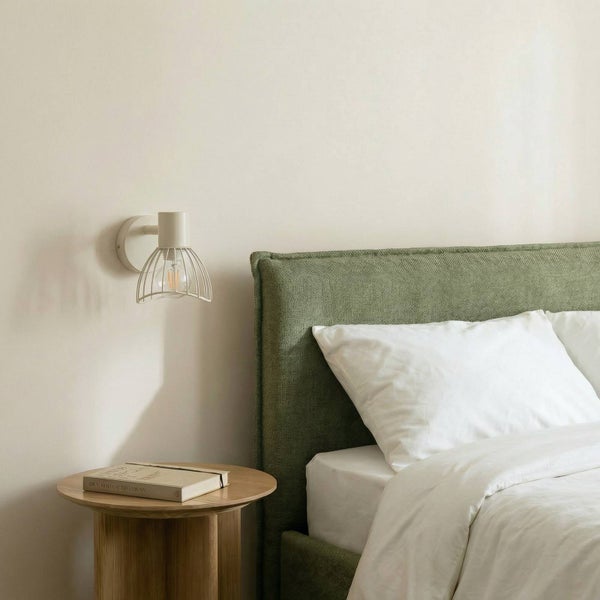 Schlafzimmer mit Bett, Nachttisch, Buch und Wandleuchte