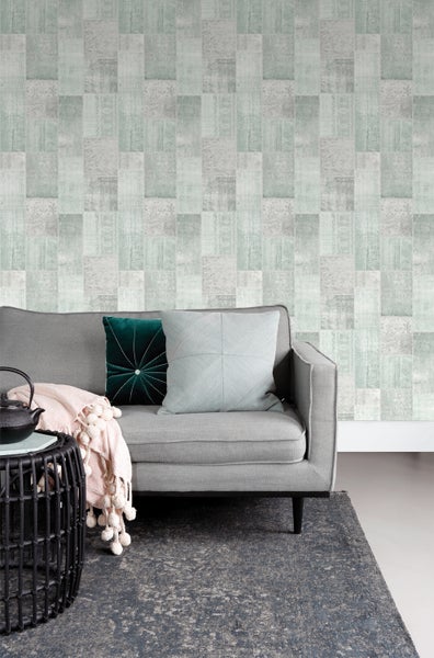 Wohnzimmer mit gemusterter Tapete, Sofa und Teppich für ein gemütliches Ambiente.