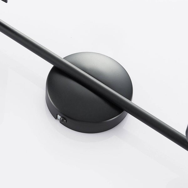 Detailaufnahme einer runden Wandhalterung aus schwarzem Metall für Leuchten mit einem Arm.