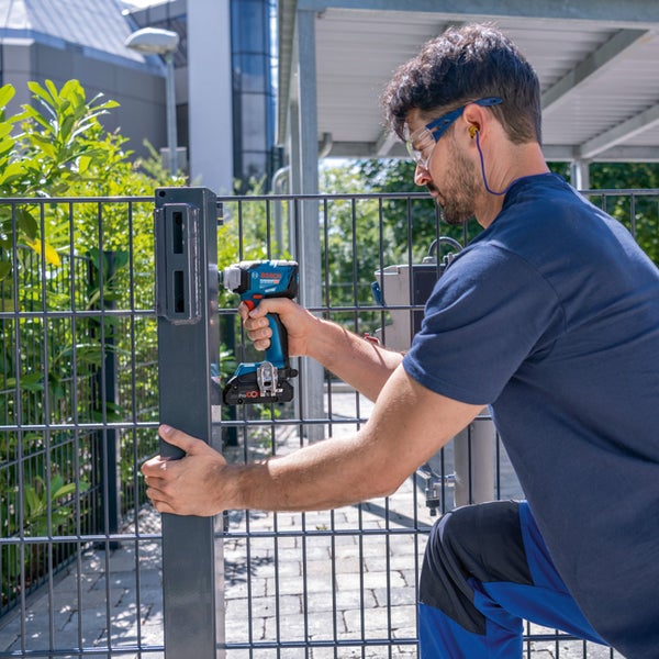 Mann montiert einen Zaunpfosten mit einem Akku-Schlagschrauber