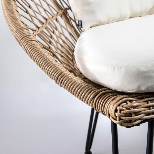 Gartensessel aus Kunststoffgeflecht mit weißem Sitzkissen und schwarzem Metallgestell.