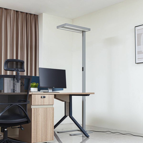 Moderner Büroarbeitsplatz mit Holzschreibtisch, ergonomischem Netzstuhl und einer schlanken LED-Stehleuchte aus Metall in Silber.