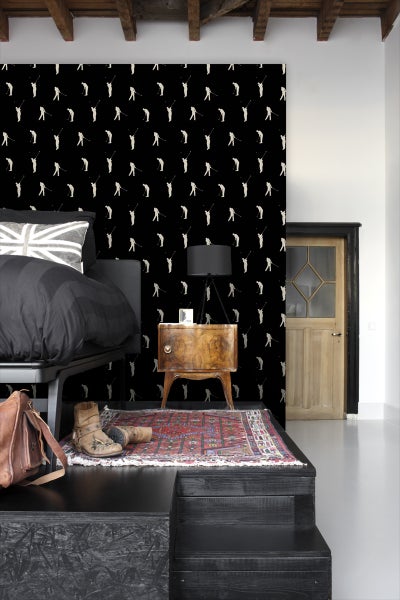 Schlafzimmer mit Bett, Nachttisch und Tapete mit Golfmotiven