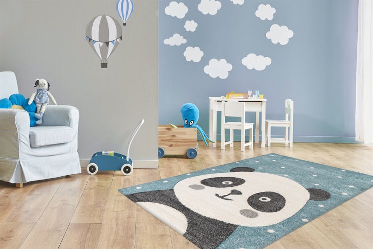 Kinderspielzimmer mit einem rechteckigen Kinderteppich mit Pandamotiv, Holzmöbeln und spielerischer Wanddekoration in einem hellen Raum.