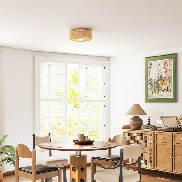 Helles Esszimmer mit rundem Holztisch, Stühlen und Rattandeckenleuchte