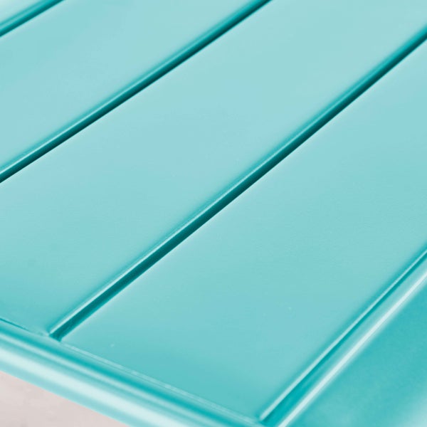 Detailaufnahme einer türkisfarbenen Metalloberfläche mit Lattenstruktur eines Gartentisches.