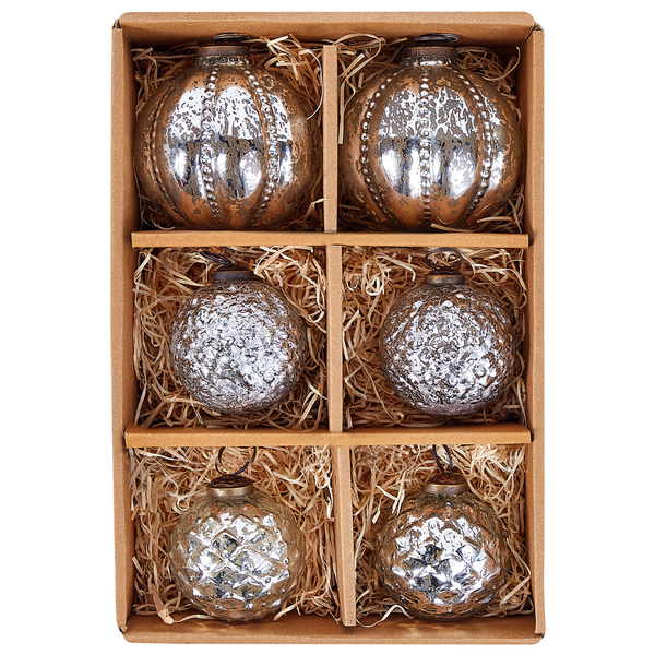 Set aus sechs gläsernen Weihnachtsbaumkugeln in Silber mit verschiedenen Oberflächenstrukturen in einer Pappschachtel mit Holzwolle.