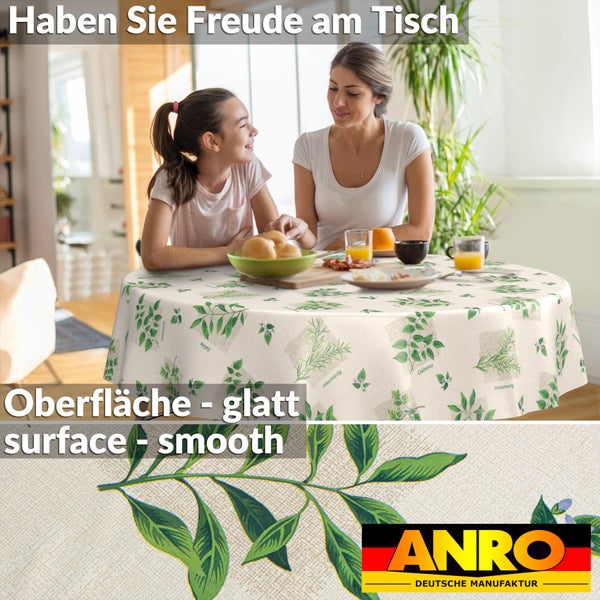 Runde Tischdecke mit Kräutermuster aus Rosmarin und Salbei auf einem Esstisch, Detailansicht der glatten Textur, ANRO Deutsche Manufaktur Logo.