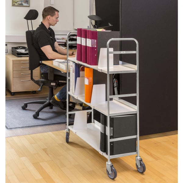 Büro mit einem Dokumentenwagen auf Rollen und Ordnern in verschiedenen Farben.