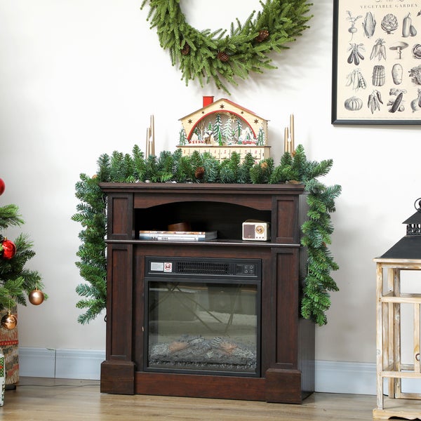 Elektrischer Kamin aus dunklem Holz mit Kaminsims, dekoriert mit weihnachtlicher Girlande, Kranz und Adventskalender aus Holz.