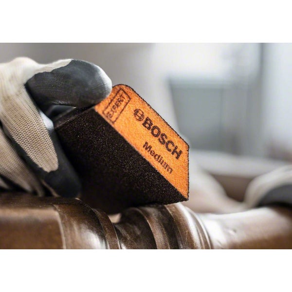 Bosch Expert Schleifklotz Medium in Verwendung mit Schutzhandschuh.