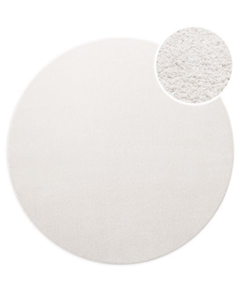 Runder Teppich in Creme mit Detailansicht der weichen Faserstruktur.
