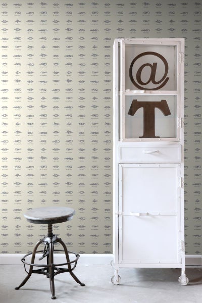 Szene mit einer Tapete mit Knotenmuster, einem weißen Metallschrank und einem Barhocker