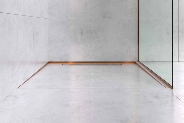 Moderne bodenebene Dusche mit hellen Fliesen in Betonoptik, einer schmalen Duschrinne und kupferfarbenen Abschlussprofilen.