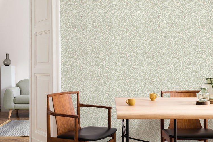 Esszimmer mit Tisch, Stühlen und grüner Blättertapete.