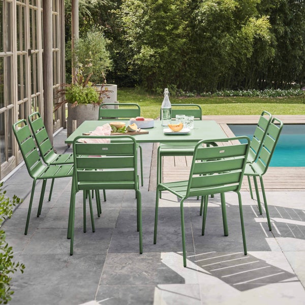 Moderne grüne Garten-Sitzgruppe aus Metall mit einem rechteckigen Tisch und sechs Stühlen auf einer Steinterrasse neben einem Pool.