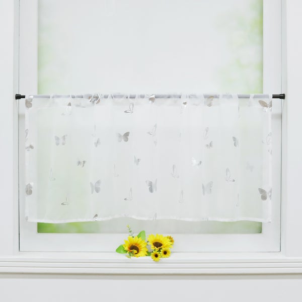 Gardinenstore mit Schmetterlingsmuster vor einem Fenster