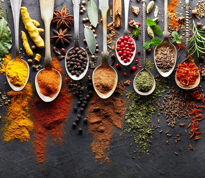 Auswahl an Gewürzen und Kräutern in Löffeln