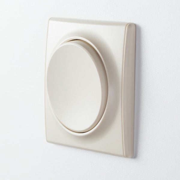 Ein runder Lichtschalter in quadratischem Rahmen an einer Wand montiert.