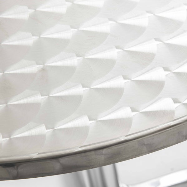 Detailansicht einer runden Tischplatte aus Metall mit dekorativem Schliffmuster.