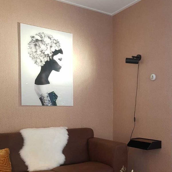 Wohnzimmer mit Sofa, Wandbild und Wandleuchte