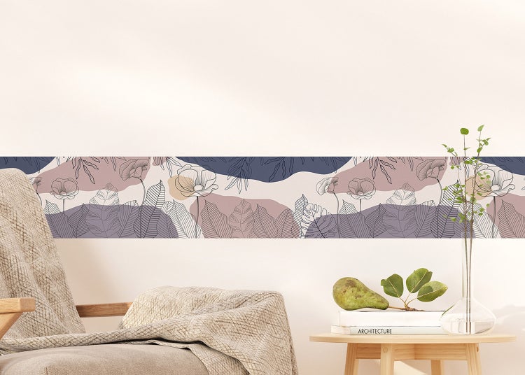 Selbstklebende Tapetenbordüre mit floralem Muster aus Blättern und Blüten in sanften Farbtönen an einer weißen Wand im Wohnzimmer.