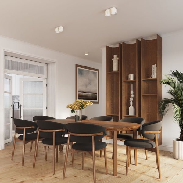 Helles Esszimmer mit ovalem Holztisch, dunkel gepolsterten Stühlen, hohem Holzregal und modernen Deckenleuchten auf hellem Holzboden.