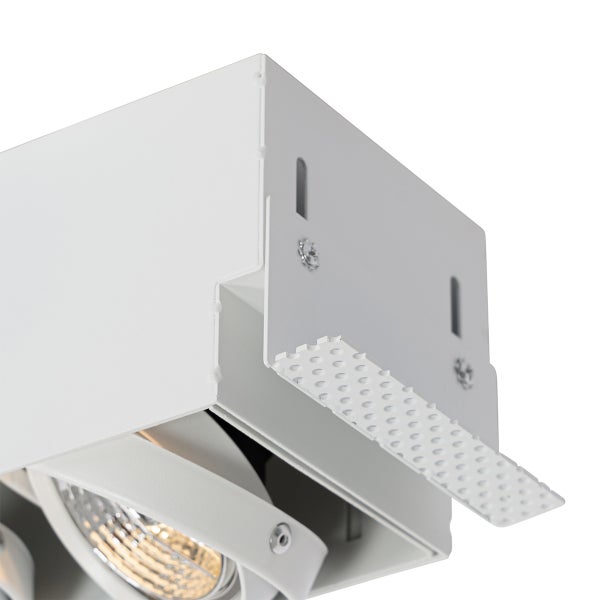 Weiße Einbauleuchte mit perforiertem Metallrahmen für den randlosen Einbau und schwenkbarem Reflektor.