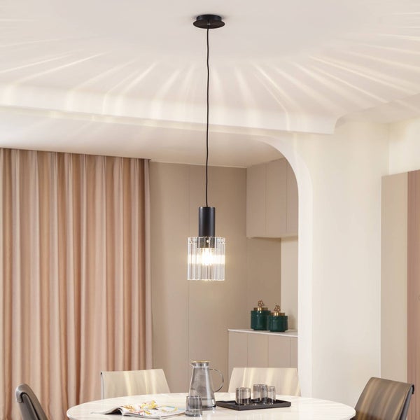 Hängelampe mit geriffeltem Glasschirm über einem Esstisch