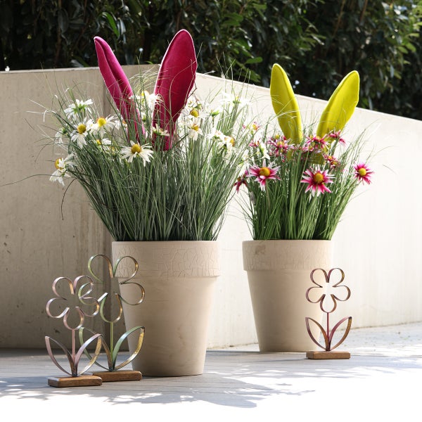Zwei Blumentöpfe mit Blumen und Hasenohren-Dekoration sowie zwei Blumenfiguren