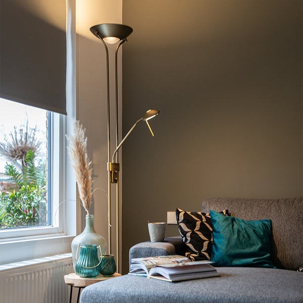 Wohnzimmer mit Stehlampe, Sofa, Kissen und Dekorationen
