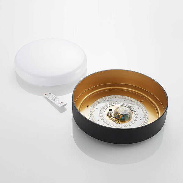Runde LED-Deckenleuchte Lindby mit schwarzem Gehäuse, goldener Innenseite, weißem Diffusor und Fernbedienung.