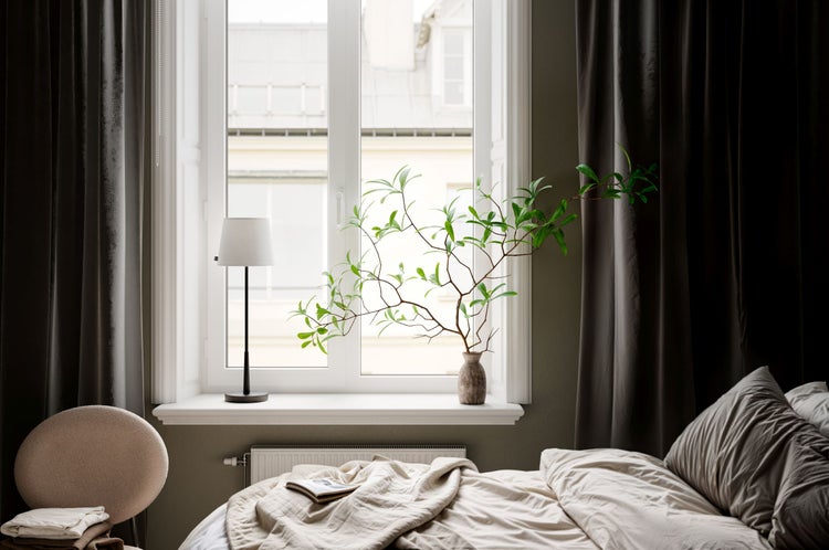 Schlafzimmer mit Bett, Vorhängen, Fenster, Tischlampe und Dekoration