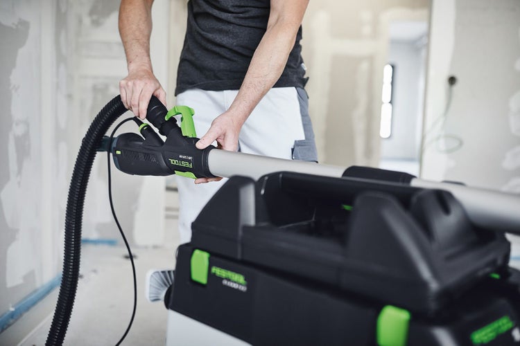 Festool Schleifgerät mit Absaugmobil und Handwerker bei der Arbeit.