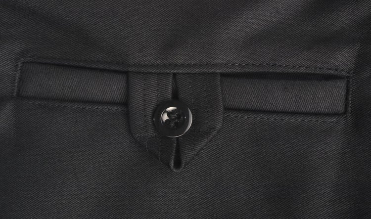 Detailaufnahme einer schwarzen Leistentasche an Arbeitskleidung mit Knopfverschluss.