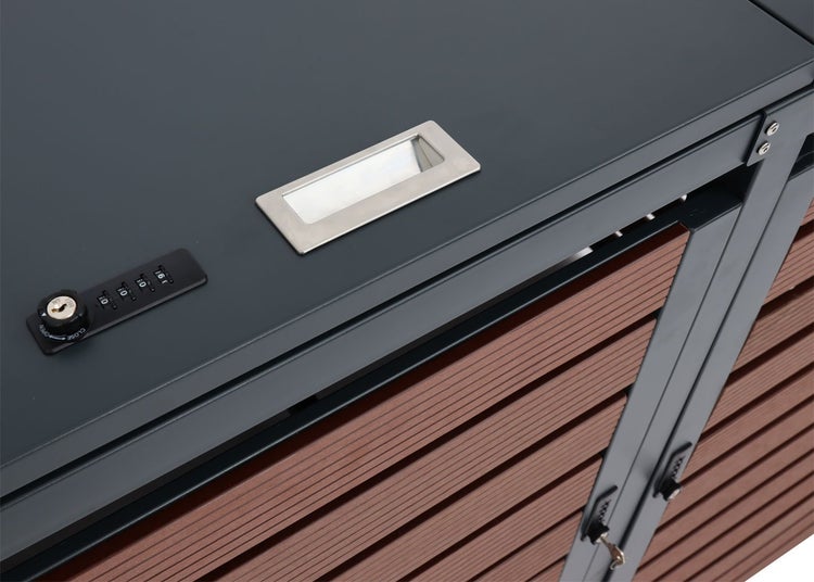 Detailansicht eines Mülltonnenbox-Deckels mit Griffmulde, Zahlenschloss und den Lamellen der Boxverkleidung.