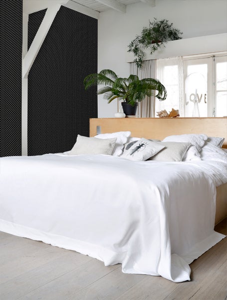 Schlafzimmer mit Bett, Kissen und Pflanzen