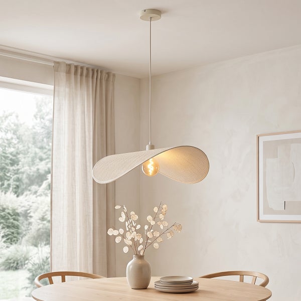 Moderne Hängelampe mit breitem, geschwungenem Lampenschirm über einem hölzernen Esstisch in einem hellen, wohnlich eingerichteten Zimmer.