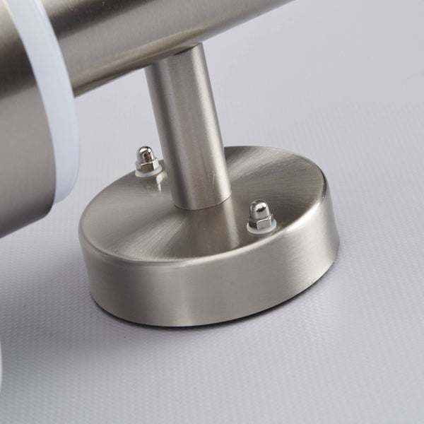 Detailaufnahme einer Wandlampenhalterung aus gebürstetem Metall mit runder Basis und Hutmuttern.