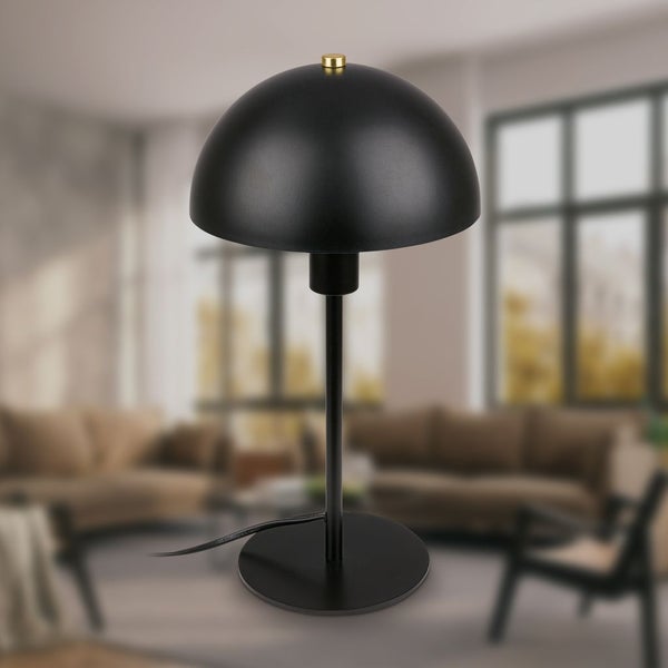 Moderne Tischleuchte in Schwarz mit kuppelförmigem Schirm und goldenem Akzent in einem hellen Wohnzimmer.