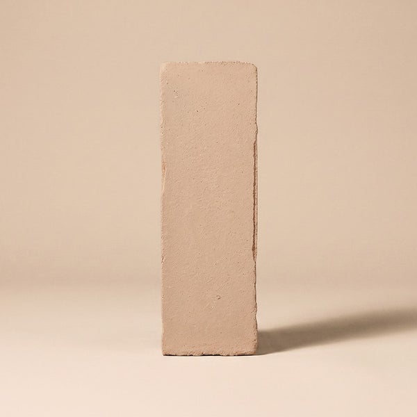 Ein einzelner rechteckiger Mauerziegel aus Ton im Hochformat.