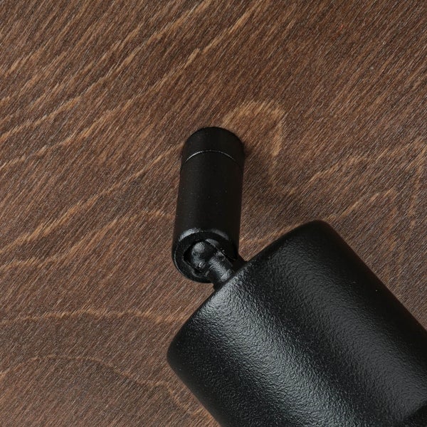 Detailaufnahme einer schwarzen Leuchte auf Holzuntergrund