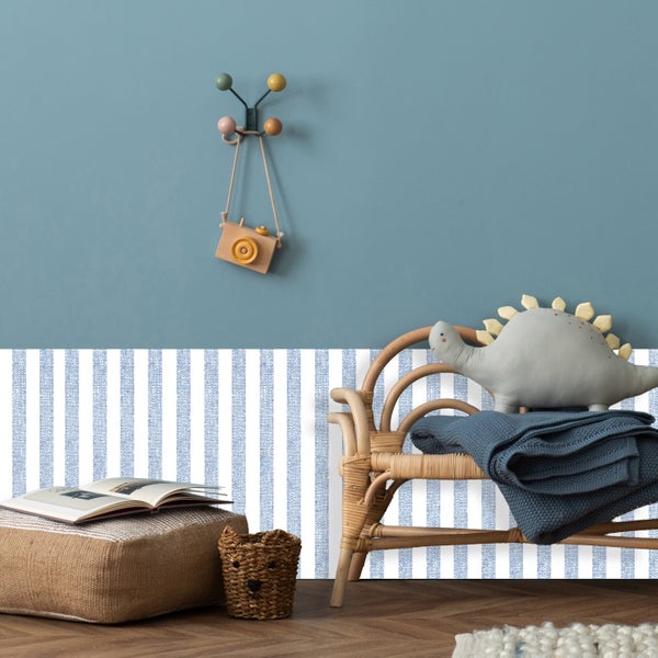 Kinderzimmer mit Rattanmöbeln, Pouf, Wandhakenleiste und Dinosaurierkissen