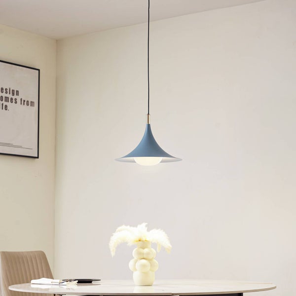 Moderne blaue Pendelleuchte in Trichterform über einem weißen Tisch in einem hellen Raum mit minimalistischem Design.