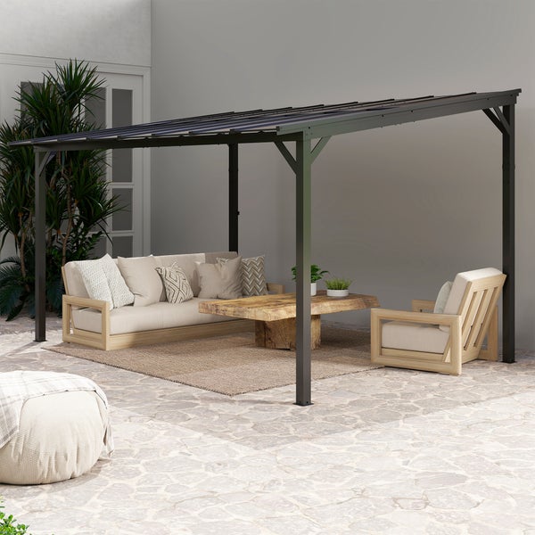 Schwarze Terrassenüberdachung aus Metall an einer Hauswand über einer Terrasse mit Holzmöbeln und Sitzgelegenheiten.