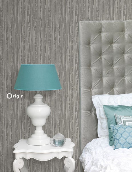 Dekoratives Schlafzimmer mit gemusterter Tapete, Nachttisch, Lampe und gepolstertem Kopfteil