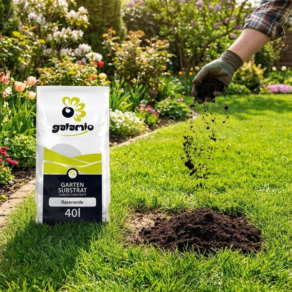 Eine Person streut Rasenerde aus einem 40 Liter Sack Galamio Garten Substrat auf eine Rasenfläche in einem hellen Garten.