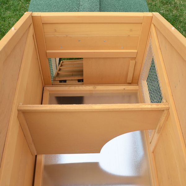 Innenansicht eines Kleintierstalls aus Holz mit einer Bodenwanne aus Metall, einer Trennwand und einer Rampe.