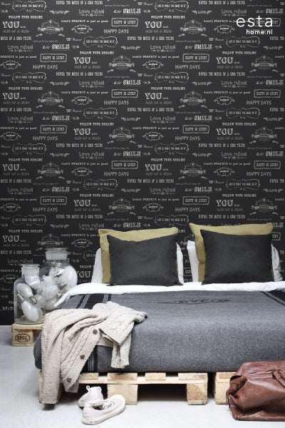 Schlafzimmer mit Bett auf Europaletten und mit Lampen gefülltem Glasgefäß